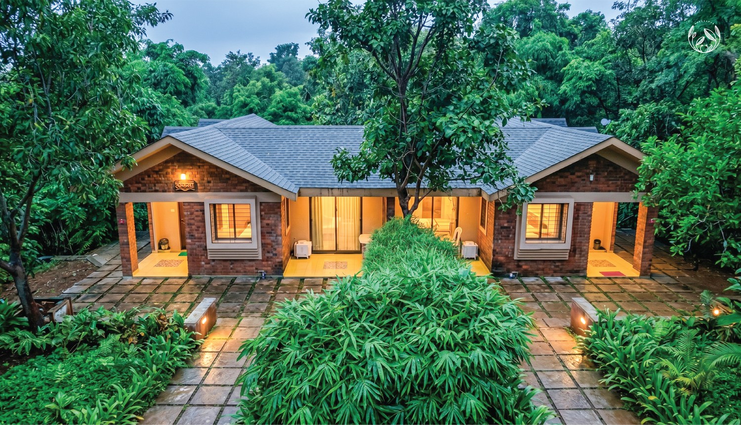 The larger countryside residence, under a sloping shingled roof.