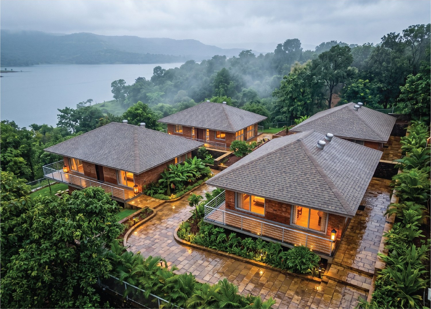 Villas stepping down the slope towards the water, in early monsoon mist.